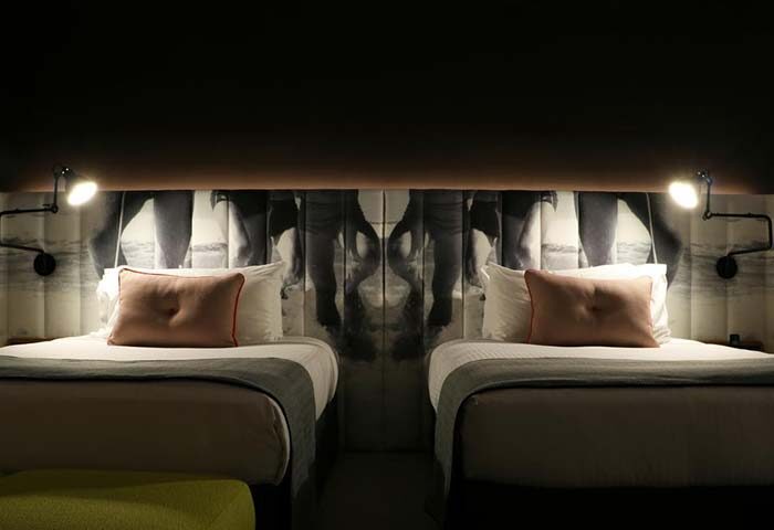 Ovolo Woolloomooloo hotel room in Sydney. Gay-friendly travel lodging with twin beds and unique headboard art. Stylish, modern design.