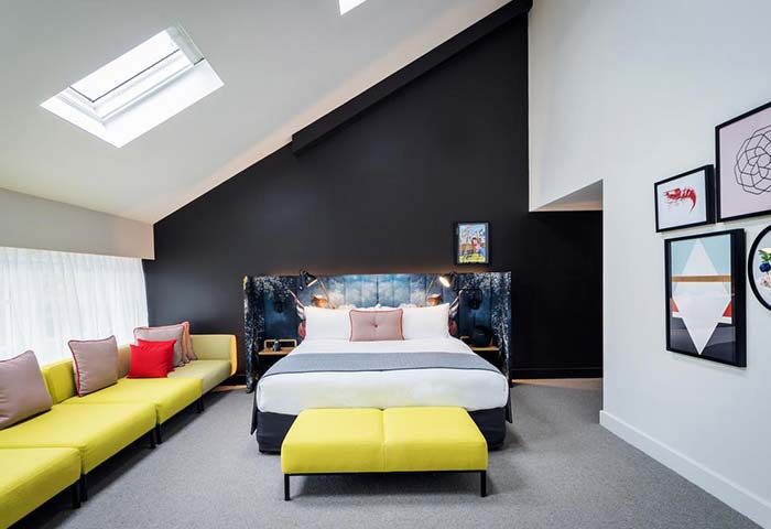 Ovolo Woolloomooloo Hotel room in Sydney. Modern design, skylight, yellow sofa, art. Gay-friendly hotel for gay men travelers.
