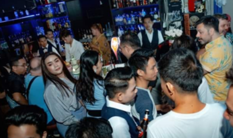 POC Bar, Phnom Penh: A lively, crowded gay bar scene. People are socializing near the bar, enjoying the vibrant atmosphere.