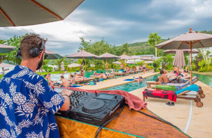 DJ spinning tunes at PP Charlie Beach Resort, Phi Phi. Gay-friendly hotel pool scene with sunbathers and tropical vibes. Cheap gay hotel.