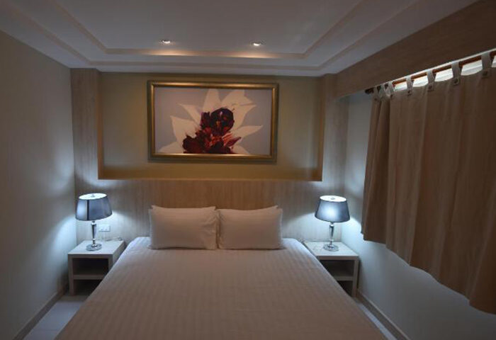 PP Charlie Beach Resort, Koh Phi Phi: Upscale room with double bed, bedside tables, lamps, and flower art. Gay-friendly hotel.