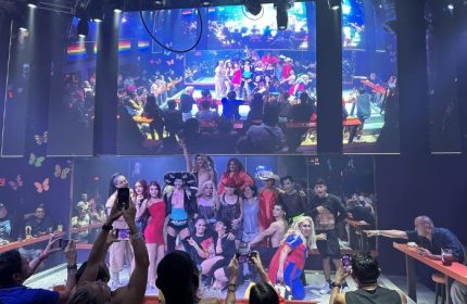 Paco's Ranch gay bar in Puerto Vallarta: Drag queens pose for photos in front of a crowd. Gay nightlife scene, popular gay travel destination.