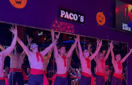Halloween show at Paco's Ranch gay bar in Puerto Vallarta. Male dancers in costumes perform on stage for a lively crowd. Gay travel.