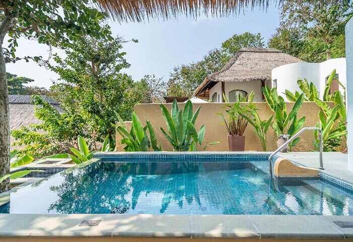 Paradee Resort Koh Samet pool villa. Beachfront resort with lush greenery, tropical plants, and a private pool, perfect for gay travel.