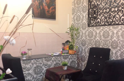 Paradise Massage Phnom Penh interior. Waiting area with chairs, table, and decorative art. Gay travel advice for relaxation and wellness.