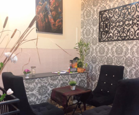 Paradise Massage Phnom Penh interior. Waiting area with chairs, table, and decorative art. Gay travel advice for relaxation and wellness.