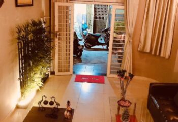 Paradise Spa, Ho Chi Minh City entrance. Open door, Welcome mat, plants, and scooter visible. Gay travel in Vietnam.