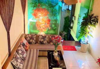 Paradise Spa in Ho Chi Minh City: Cozy waiting area with sofa, coffee table, flowers, and plants. A relaxing gay travel destination.