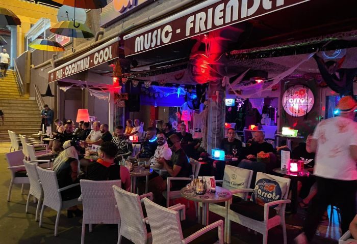 Parrots Pub, a gay bar in Yumbo Centre, Maspalomas, Gran Canaria. Features outdoor seating, Halloween decorations, and a vibrant, friendly atmosphere.