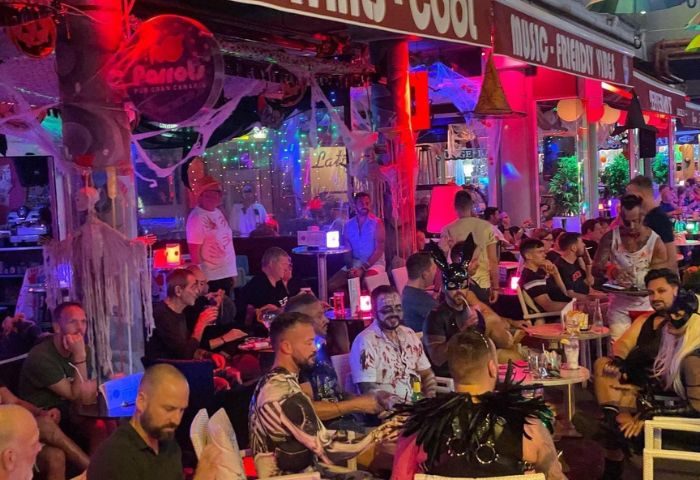 Parrots Pub Gran Canaria: Gay bar in Yumbo Centre, Maspalomas. Men in costumes, Halloween decorations, and a lively atmosphere.