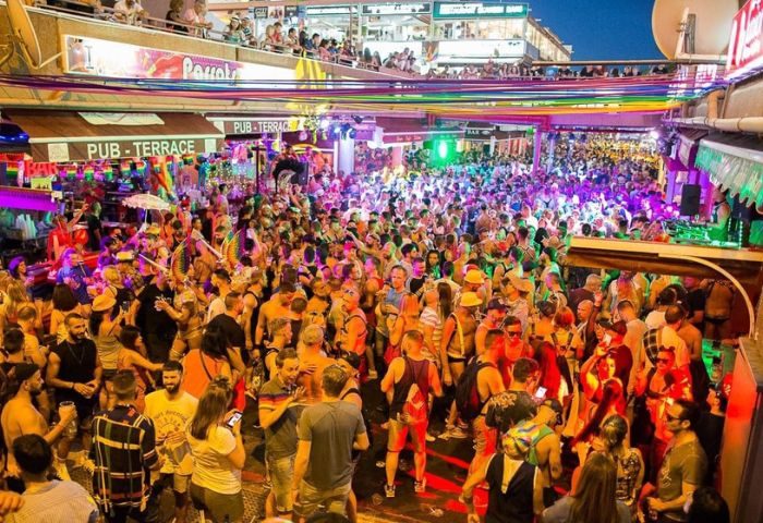 Gay nightlife at Parrots Pub, a popular gay bar in Yumbo Centre, Maspalomas, Gran Canaria. Crowded scene, rainbow decorations.