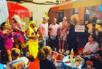 Parrots Pub terrace, a gay bar in Sitges. Drag queens and patrons gather for a show or event at this popular gay travel destination.
