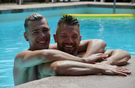 Gay couple at Paso Chico Gay Hotel, most booked hotel among gay men. Two men in a pool smiling, enjoying their vacation.