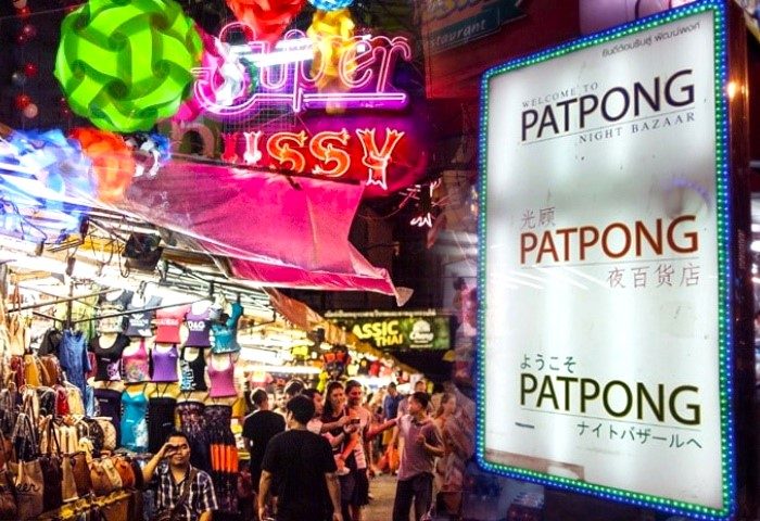 Patpong Soi 2 Bangkok night scene. Gay bars, go-go boys, and night bazaar. Neon signs, crowds, & market stalls. A vibrant gay travel destination.