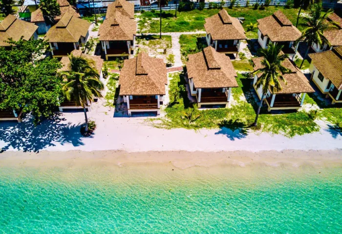 Pawapi Resort Koh Mook: Aerial view of beach bungalows on white sand with turquoise water. Gay travel to Trang, Thailand.