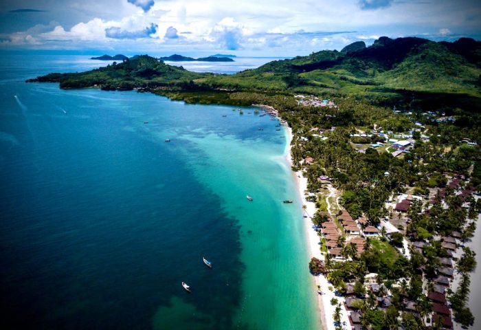 Explorer Pawapi Resort Koh Mook, Trang. Aerial view of beach, turquoise sea, and lush green island. Gay travel destination.