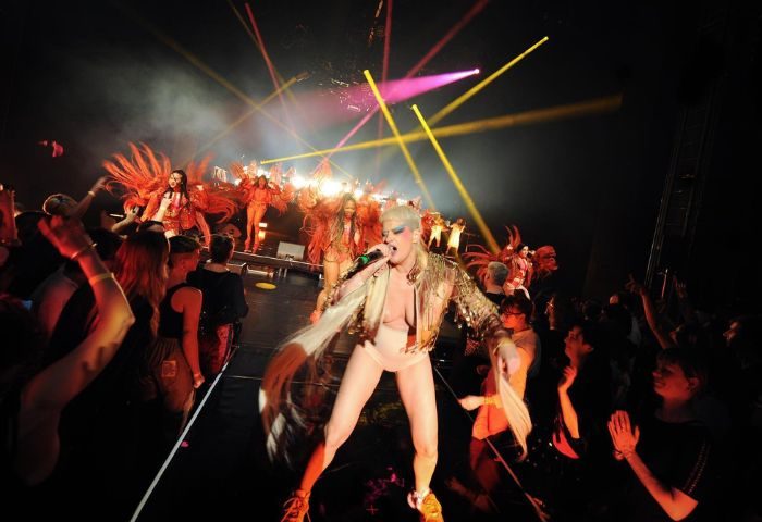 Peaches performing in Toronto. Gay travel scene with a crowd enjoying the show. Stage lights and performers in costumes. Toronto nightlife.
