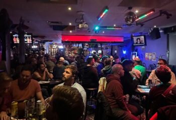 Pegasus on Church gay bar in Toronto. A lively, crowded scene of gay men enjoying drinks and socializing in a dimly lit space.