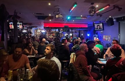 Pegasus on Church gay bar in Toronto. A lively, crowded scene of gay men enjoying drinks and socializing in a dimly lit space.