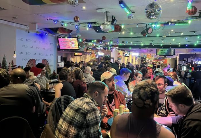 Interior of Pegasus On Church, a gay bar in Toronto. Crowded scene with patrons, rainbow decor, and disco balls. Gay travel advice.