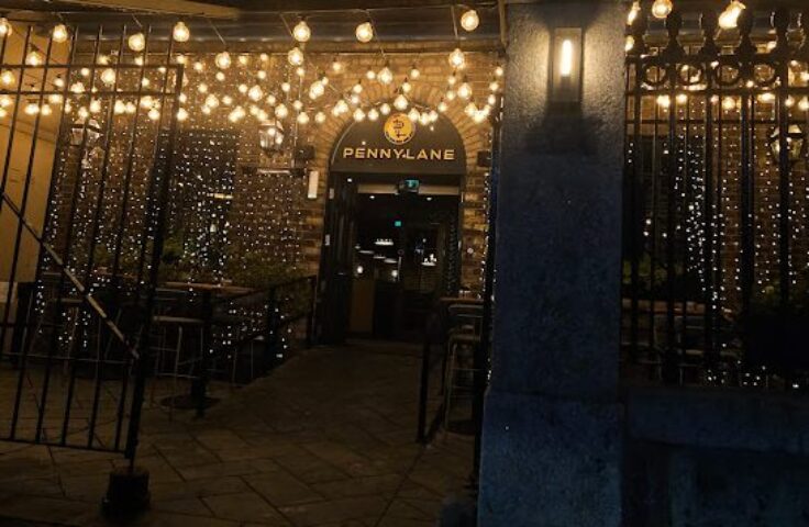 Night view of Penny Lane Gay Bar in Dublin. Entrance decorated with lights. Gay travel destination.