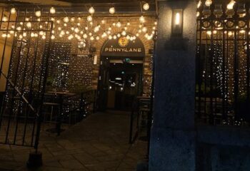 Night view of Penny Lane Gay Bar in Dublin. Entrance decorated with lights. Gay travel destination.