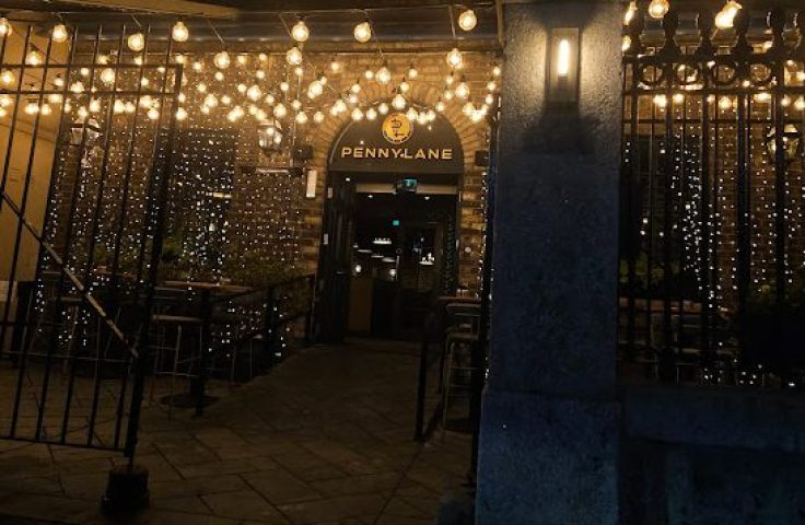 Night view of Penny Lane Gay Bar in Dublin. Entrance decorated with lights. Gay travel destination.