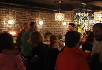 Inside Penny Lane Gay Bar Dublin. Brick walls, warm lighting, people socializing. Dublin's gay scene offers a welcoming spot for travelers.