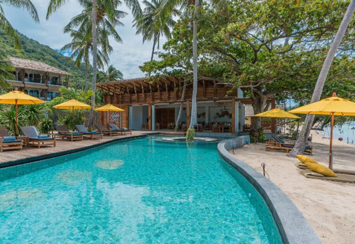 Princess Paradise Koh Phangan beachfront pool. Gay hotel with cheap price. Tropical beach, palm trees, and inviting turquoise water.