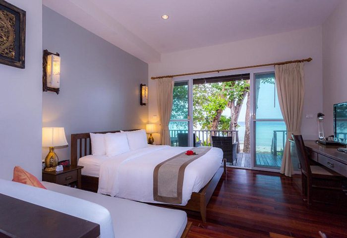 Phi Phi Holiday Resort beachfront room. Gay couples' hotel with balcony, sea view, king bed, and desk. Perfect for a gay holiday.