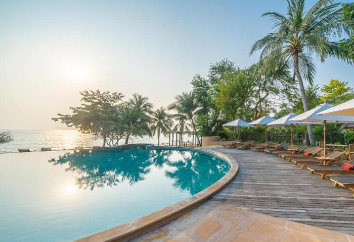 Beachfront infinity pool at Paradee Resort, Koh Samet. Luxury gay hotel with perfect Instagram views, palm trees, and lounge chairs.