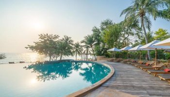 Beachfront infinity pool at Paradee Resort, Koh Samet. Luxury gay hotel with perfect Instagram views, palm trees, and lounge chairs.