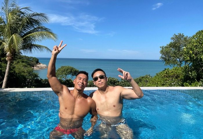 Gay honeymoon at Garrya Tongsai Bay, Koh Samui. Two men in a beachfront hotel pool with ocean view. Perfect gay travel destination.