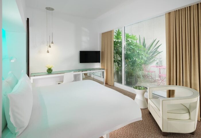 St Martins Lane Hotel London bedroom. Perfect gay honeymoon hotels in Covent Garden, City Center. Interior with bed, desk, chair, and garden view.