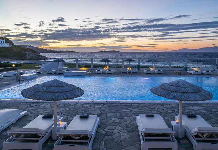 Mykonos Bay Resort beachfront hotel pool at sunset. Perfect gay honeymoon destination, luxury villas, and relaxing beach vacation.