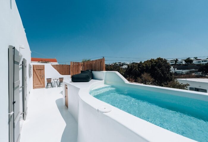 Akkadian Gay Hotel Mykonos pool villa. Perfect gay honeymoon spot with private pool, white architecture, and sunny skies. Gay-only luxury travel.