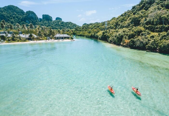 SAii Phi Phi Island Village: Gay honeymooners kayaking in crystal clear water. Perfect private beach pool villa for LGBTQ+ travel. Tropical paradise.