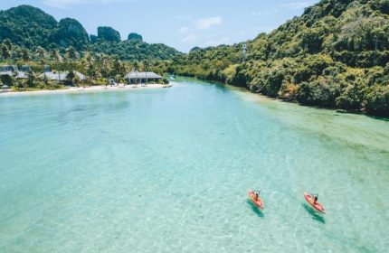 SAii Phi Phi Island Village: Gay honeymooners kayaking in crystal clear water. Perfect private beach pool villa for LGBTQ+ travel. Tropical paradise.