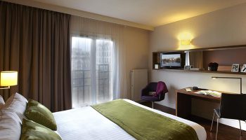 Citadines Les Halles Paris room. Gay-friendly hotel near gay bars, cruise clubs. Comfortable bed, desk, TV, chair. Perfect for gay travelers.