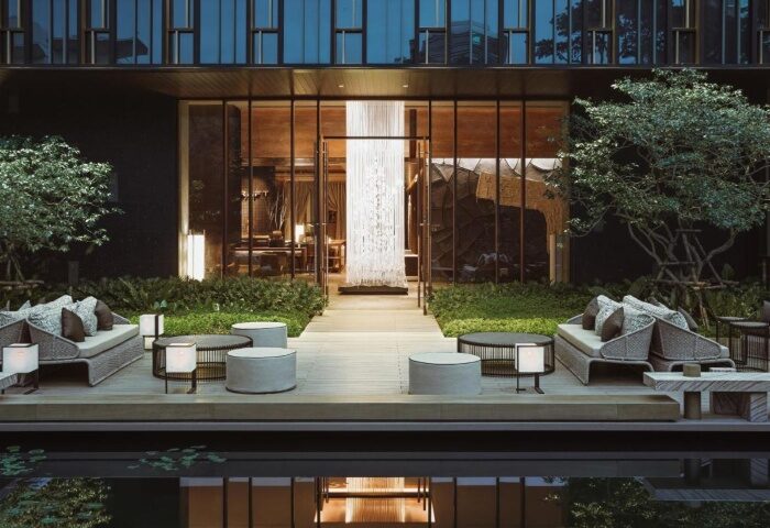 Kimpton Maa-Lai Bangkok outdoor lounge. Perfect gay hotels near Bangkok's gay bars. Stylish seating, serene garden, and modern design.