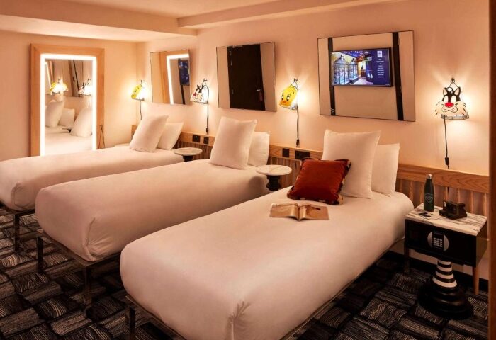 Mama Shelter London Shoreditch triple room. Perfect gay hotel for three people. Modern interior with three beds, cartoon lamps, and stylish decor.