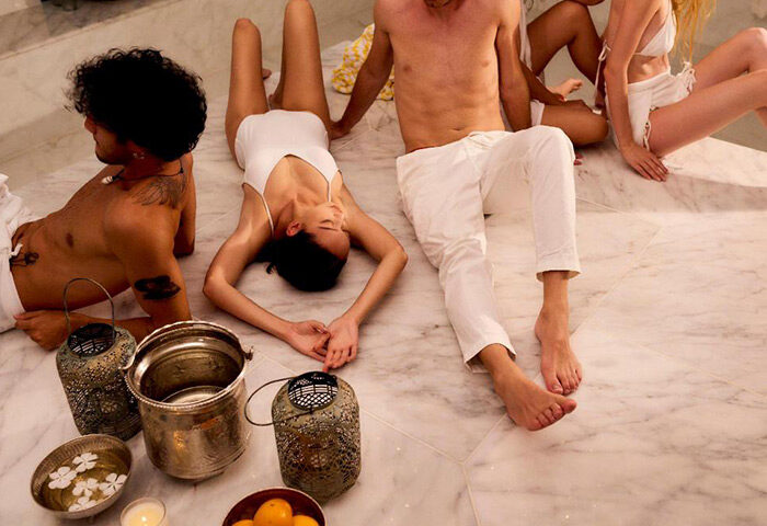 Gay group friends relax at The Standard, Huruvalhi Maldives. Perfect gay hotels for men's travel advice. Spa day, marble floor.