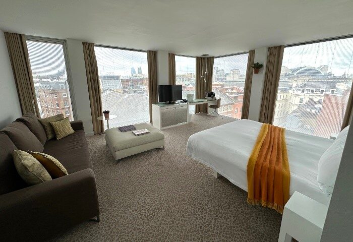 St Martins Lane Hotel, London. Perfect honeymoon hotels for gay couples. Spacious room with city views, sofa, bed, desk. Gay travel.