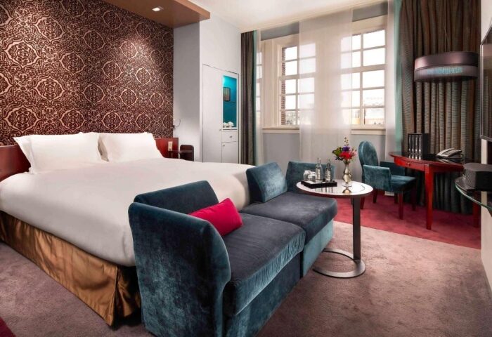 Sofitel Legend The Grand Amsterdam luxury hotel room. Perfect for gay couples' Amsterdam trip. Double bed, couch, desk, and large windows.