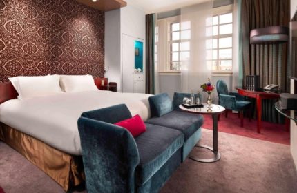 Sofitel Legend The Grand Amsterdam luxury hotel room. Perfect for gay couples' Amsterdam trip. Double bed, couch, desk, and large windows.