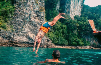 Gay man diving into the sea at The Beach Hostel, a perfect party hostel for budget gay travellers. Slumber party fun in Thailand.