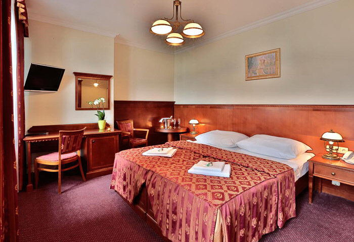Hotel Arkada Praha room. Perfect weekend getaway in Prague's gayborhood, Vinohrady. Double bed, desk, TV, & sitting area.