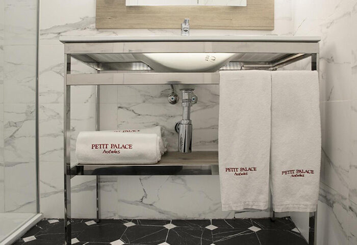 Petit Palace Chueca Hotel bathroom sink, towels. Top choice gay hotel in Madrid gayborhood. Marble tile, modern design.