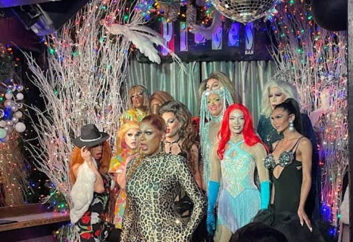 Drag queens at Pieces Bar in New York. Gay travel destination with performers in colorful costumes and makeup. Nightlife scene.