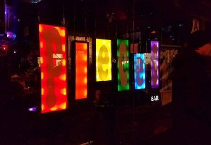 Pieces Bar in New York: Colorful sign at this popular gay bar. A nightlife hotspot with a fun, friendly atmosphere. Gay travel advice.